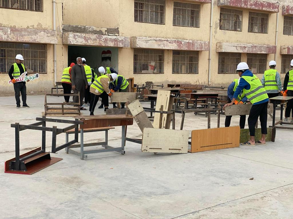 بالصور: متطوعون في الناصرية يعملون على صيانة " الرحلات المدرسية" في منطقة حي الفداء
